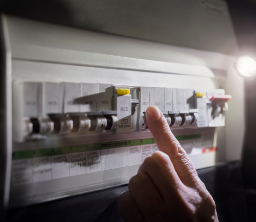 Main devant un panneau électrique appuyant sur les boutons de celui-ci à Orthez