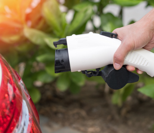 Prise de chargement en borne de recharge électrique tenue par une main